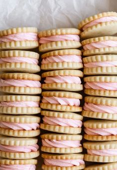 several cookies with pink frosting stacked on top of each other