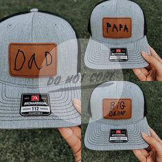 two hats that say dad and papa on the front, one is grey with brown leather