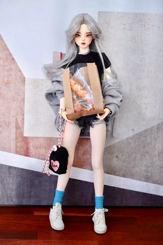 a doll is holding a paper bag with donuts in it's hands while standing on a wooden floor