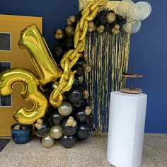 balloons and streamers are on the floor next to a large number 3 balloon sculpture