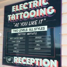 a sign on the side of a building that says electric tattooing as you like it two levels all styles