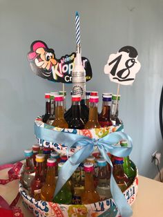 a cake made to look like a basket full of sodas and beer bottles with a blue ribbon tied around the top