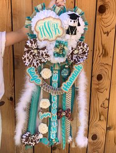 a person is holding up a display made out of cookies and other items that are hanging on a wooden wall