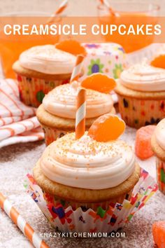 cupcakes with white frosting and orange candies on top, surrounded by candy sticks