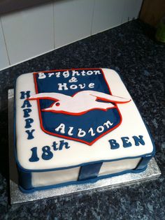 a blue and white birthday cake with an eagle on the front is for brighton & hover