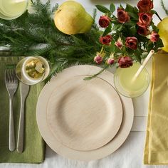 a table set with plates, silverware and flowers