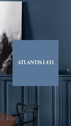 a blue wall with the words atlantics l38 on it in front of a table and chair