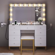 a white vanity with lights on it and a stool in front of the mirror that is lit up