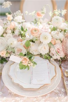 an elegant table setting with white and pink flowers, greenery and menu card on the plate