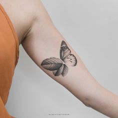 a woman's arm with a butterfly tattoo on the left side of her arm