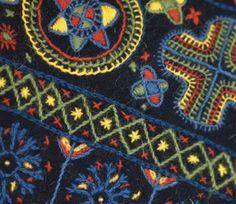 close up view of an embroidered cloth with colorful designs and crosses on the front side