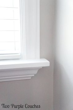 the corner of a room with a window and white paint on the walls is shown