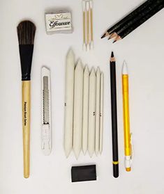 various pens, pencils, and other items laid out on a white table top