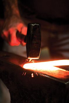 a man is working with an object in his hand and it's light shining on the table