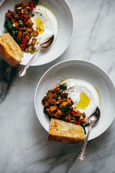 two white bowls filled with food on top of a table