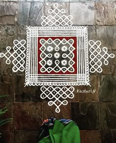 a person standing in front of a stone wall with an intricately designed design on it