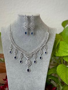 Extremely Gorgeous and Pretty White gold Plated CZ necklace with matching earrings is an elegant set for your local gatherings or parties! Measurements of the earrings: -------------------------------- Height of the earrings: 6.5 cm Width: 2 cm Care Instruction : Avoid Heat & Chemicals Like Perfume, Deo, Alchol, Etc. | Clean With Dry Cotton Cloth | Pack In our Anti tarnish box after use. White Necklace Set, Cubic Zirconia Jeweled Jewelry Sets For Celebration, Cubic Zirconia Jewels Jewelry Sets For Celebration, Cubic Zirconia Jewelry Sets For Celebration, Crystal Jewelry Sets With Jewels For Celebration, Crystal Jewelry Sets For Celebration, Hand Set Cubic Zirconia Dangle Necklaces, Handcrafted Cubic Zirconia Dangle Necklaces, Cubic Zirconia Dangle Bridal Necklace For Party