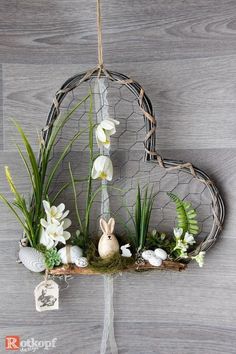 a heart shaped hanging decoration with flowers and eggs