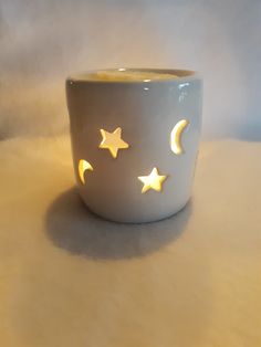 a white cup with yellow stars and moon lights on the inside is sitting on a table