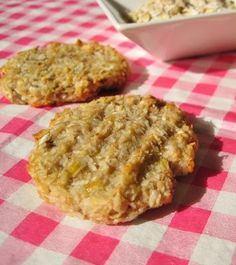 two oatmeal cookies sitting on top of a pink and white checkered table cloth