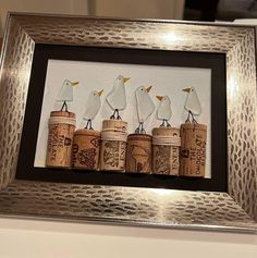 three white birds sitting on top of wine corks in a framed frame with the words happy new year written below them