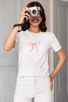 Add a touch of sweetness to your wardrobe with this adorable pink bow t-shirt! This women's t-shirt features a charming pink bow printed design that is both cute and stylish. Made from high-quality materials, this top is perfect for adding a pop of color to any outfit. Whether you're heading out for a casual day out or just want to add a fun element to your look, this sweet pink bow t-shirt is sure to become a favorite in your collection. Casual Short Sleeve T-shirt With Pink Bow, Feminine Pink Crew Neck T-shirt, Cute Pink T-shirt With Bow, Summer Bow T-shirt With Short Sleeves, Summer T-shirt With Bow And Short Sleeves, Summer Bow Detail Short Sleeve T-shirt, Summer Short Sleeve T-shirt With Bow, Cotton Crew Neck T-shirt With Bow Print, Cute Cotton T-shirt With Pink Bow