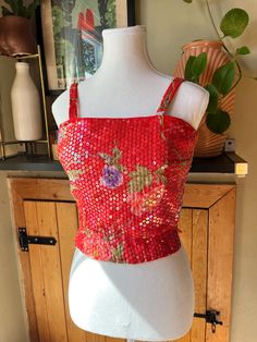 This dazzling Midcentury crop top is vibrantly coloured with a pretty floral pattern. It is covered in iridescent sequins to add sparkle and shine to your outfit while having a tropical feel. The top has spaghetti straps, a fitted waist, and zips up the back with a metal zipper.  Label: Helen H. Halpern Size: none indicated but fits like an extra small (no stretch to fabric except waistband) Measurements (taken flat): Pit to pit - 16.5" Waist - 12" to 13" stretched Shoulder to hem - 17" Pit to h Glamorous Summer Festive Crop Top, Festive Cropped Tops, Fitted Festive Crop Top, Festive Cropped Tops For Party, Festive Cropped Party Tops, Festive Cropped Top For Parties, Retro Sleeveless Party Top, Red Fitted Top For Party Season, Glamorous Fitted Crop Top For Festive Season