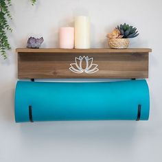 a wooden shelf with two blue yoga mats on it and candles next to it,