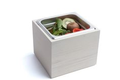 a square container filled with assorted fruits and veggies on top of a white surface