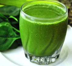 a green smoothie in a glass on a plate