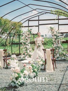 a woman in a white dress standing next to flowers and chairs with the words prourn written on it