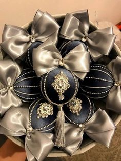 a basket filled with lots of silver and black bows on top of a table next to a wall