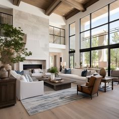 a living room filled with lots of furniture next to a fire place and large windows