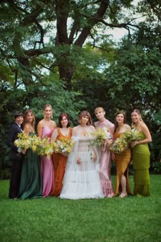 a group of women standing next to each other on top of a lush green field