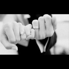 black and white photograph of a woman holding her engagement ring in one hand with the other