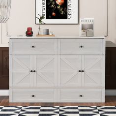 a white dresser sitting in a room next to a black and white checkered floor