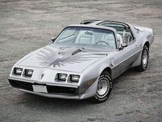 a silver pontiac sports car parked in a parking lot