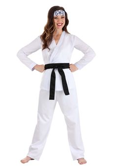 a woman wearing a white karate outfit with black belt and headbands, standing in front of a white background