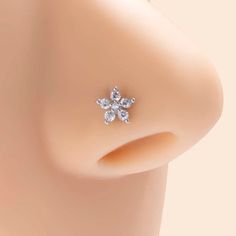 a close up view of a nose with an earring in the shape of a flower