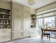 a dining room table and chairs with built in bookshelves next to the window