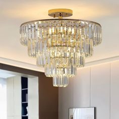 a crystal chandelier hanging from the ceiling in a living room with white walls