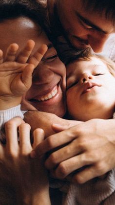 two adults and a child are hugging each other