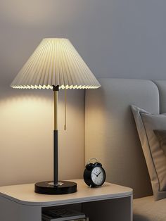 a lamp that is sitting on top of a night stand next to a book shelf