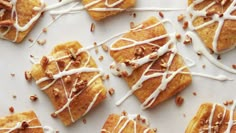 several pieces of pastry with white icing and nuts