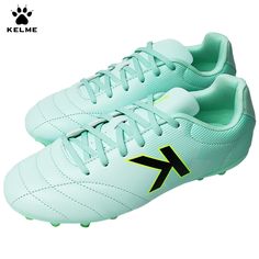 a pair of green soccer shoes with black and yellow letters on the upper soles