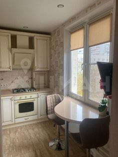 a kitchen with a table and chairs next to a window