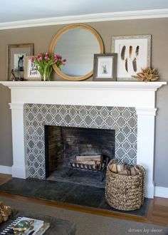 a fireplace with a mirror above it and pictures on the mantels over top