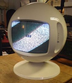 an old tv sitting on top of a wooden table