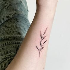 a woman's arm with a small flower tattoo on it