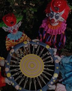 two creepy clowns are holding a spinning wheel